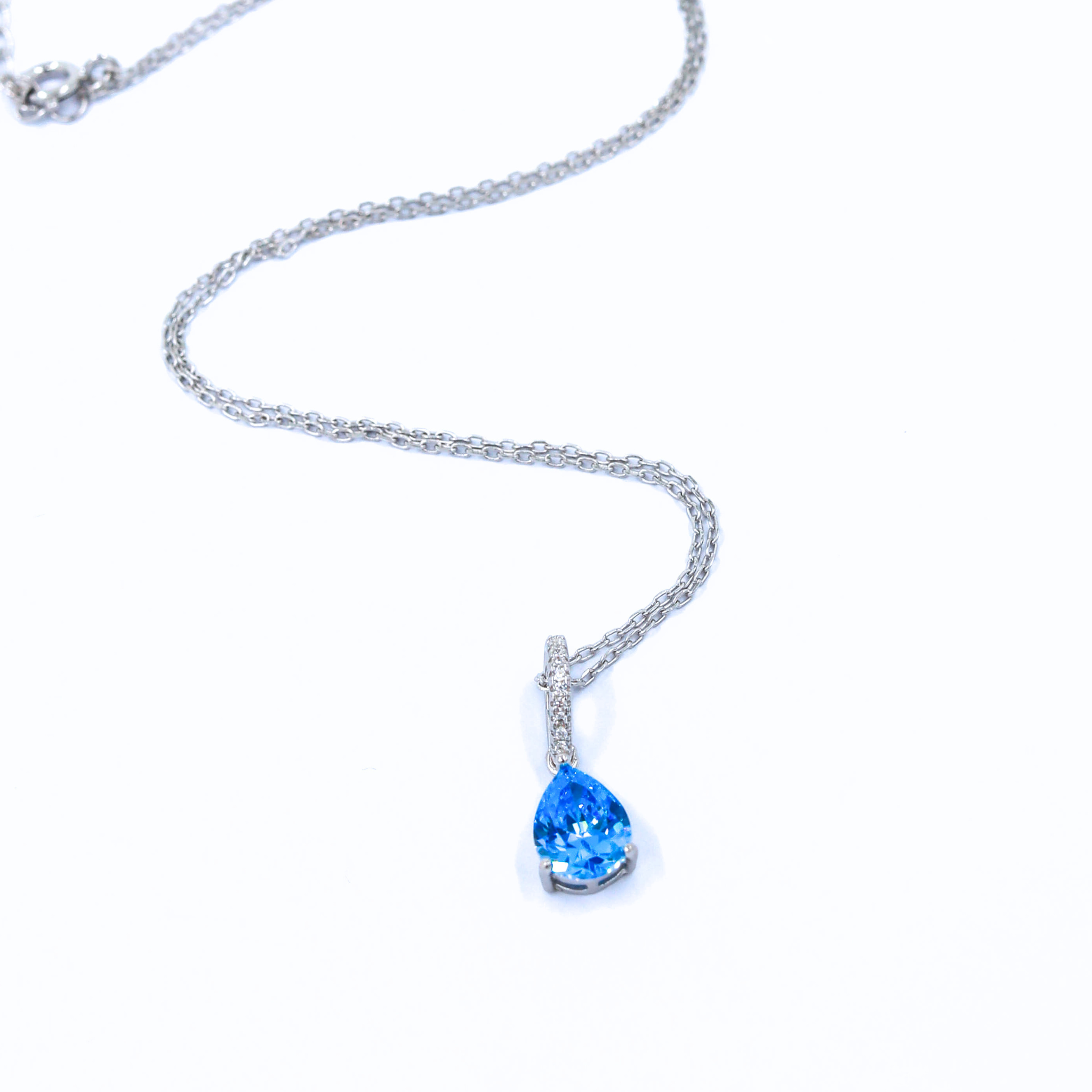 A stunning sterling silver necklace with a blue stone, showcased on a white background
