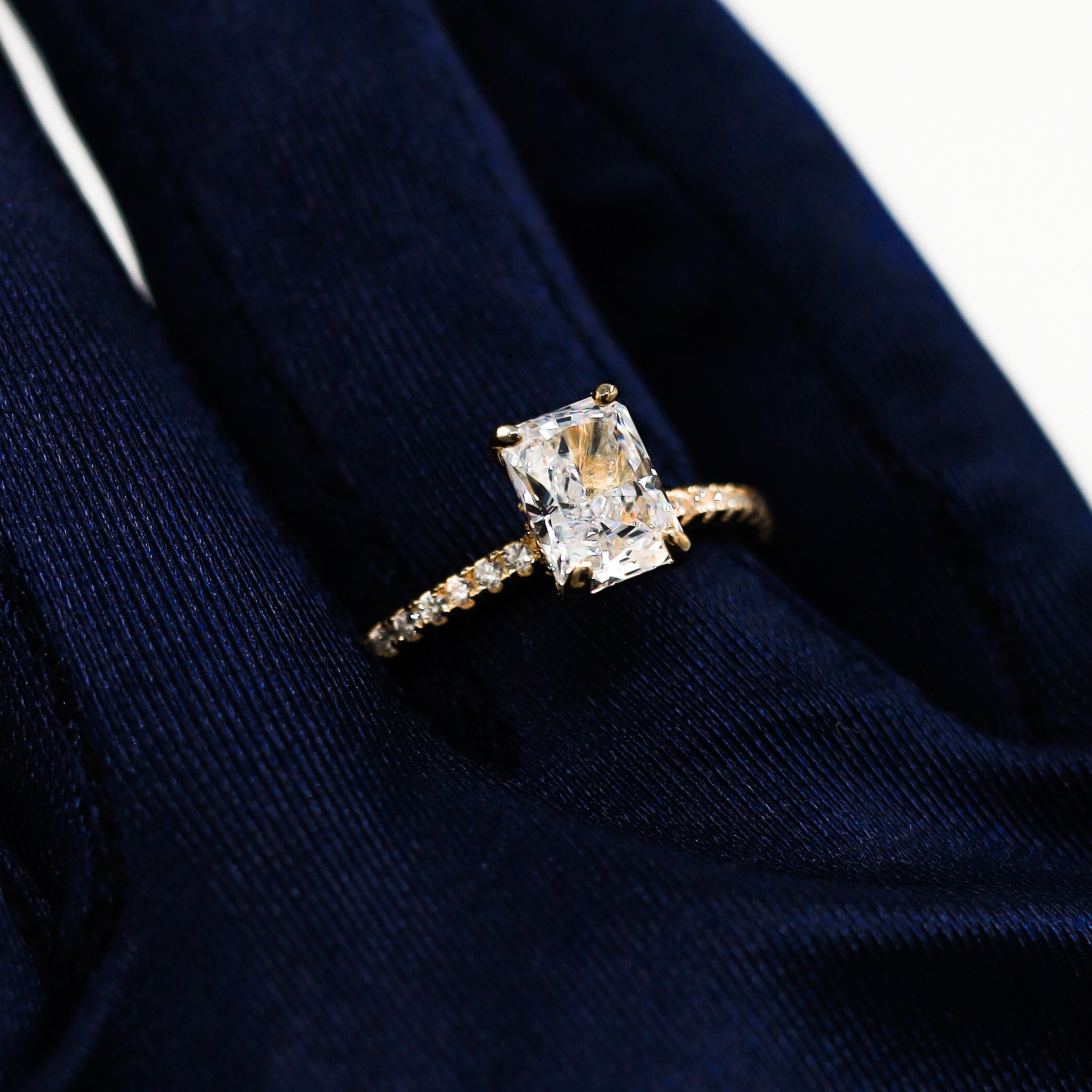 Kapi Rectangular Cut Ring in Gold worn on finger, highlighting the sleek gold-plated finish and eye-catching rectangular center stone with pave cubic zirconia for a refined look.
