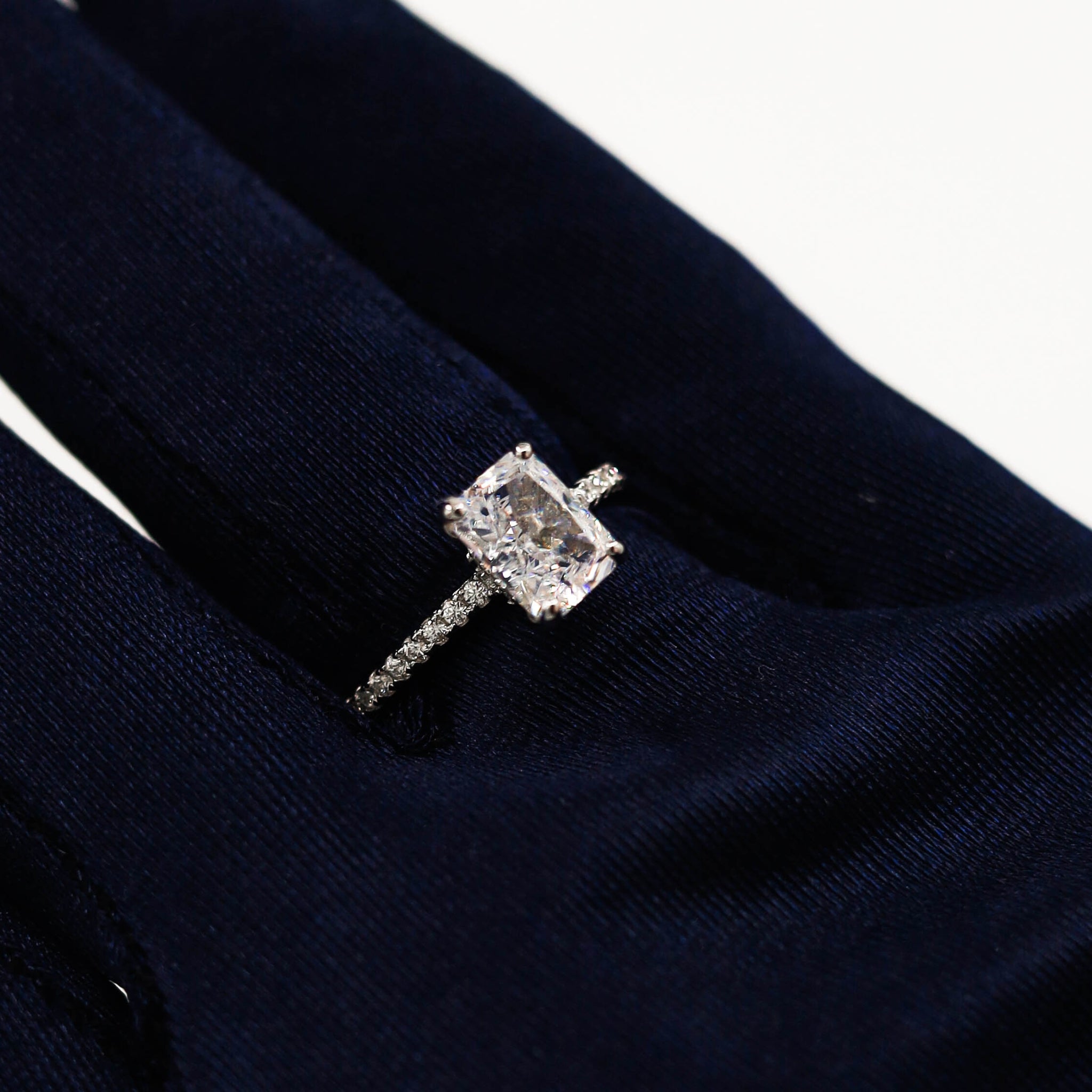 Kapi Rectangular Cut Ring in Silver worn on finger, highlighting the elegant rectangular-cut center stone and pave cubic zirconia accents for a sophisticated, fashionable look. Rhodium plated