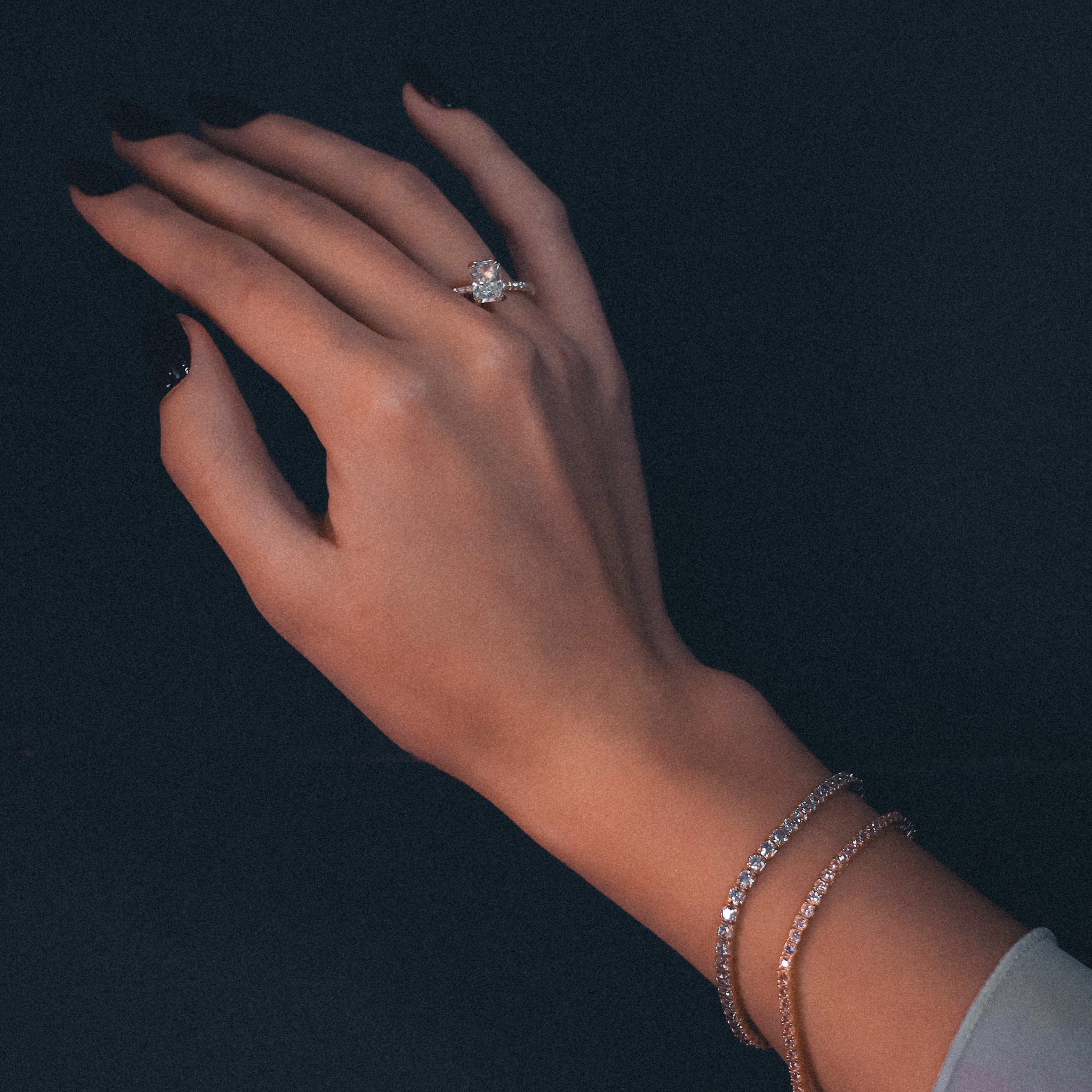 Tennis Bracelet Bijou in Gold worn on the wrist, showcasing the radiant blue cubic zirconia stones set in gold plating, ideal for an elegant and timeless accessory. Combined with our rose tennis bracelet, as well as our stunning ring Kapi in gold.