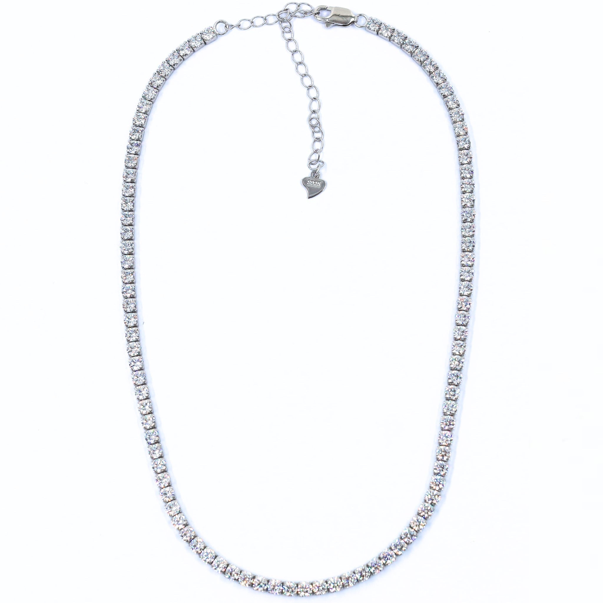Silver Tennis Necklace featuring a delicate line of sparkling cubic zirconia stones set in a sleek, polished sterling silver chain, perfect for adding elegance to any outfit. Rhodium plated, with an adjustable clasp to regulate how tight or loose the necklace looks on the neck
